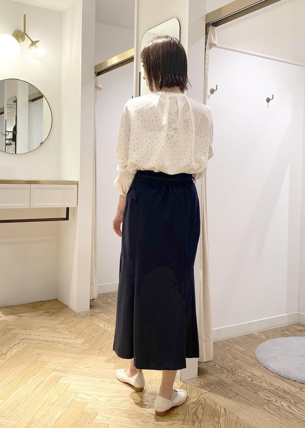 ホワイト系のパンプス、ブラック系のボストンバッグ、ホワイト系のシャツ/ブラウスを着用したレディースの春コーディネートの2枚目の写真