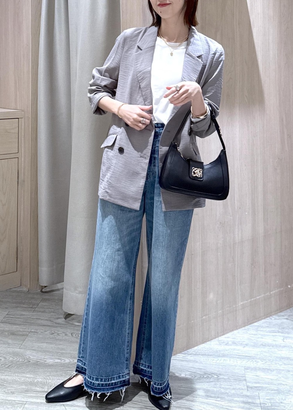 ブラック系のショルダーバッグ、ブラック系のパンプス、ホワイト系のTシャツ/カットソーを着用したレディースの春コーディネートの2枚目の写真