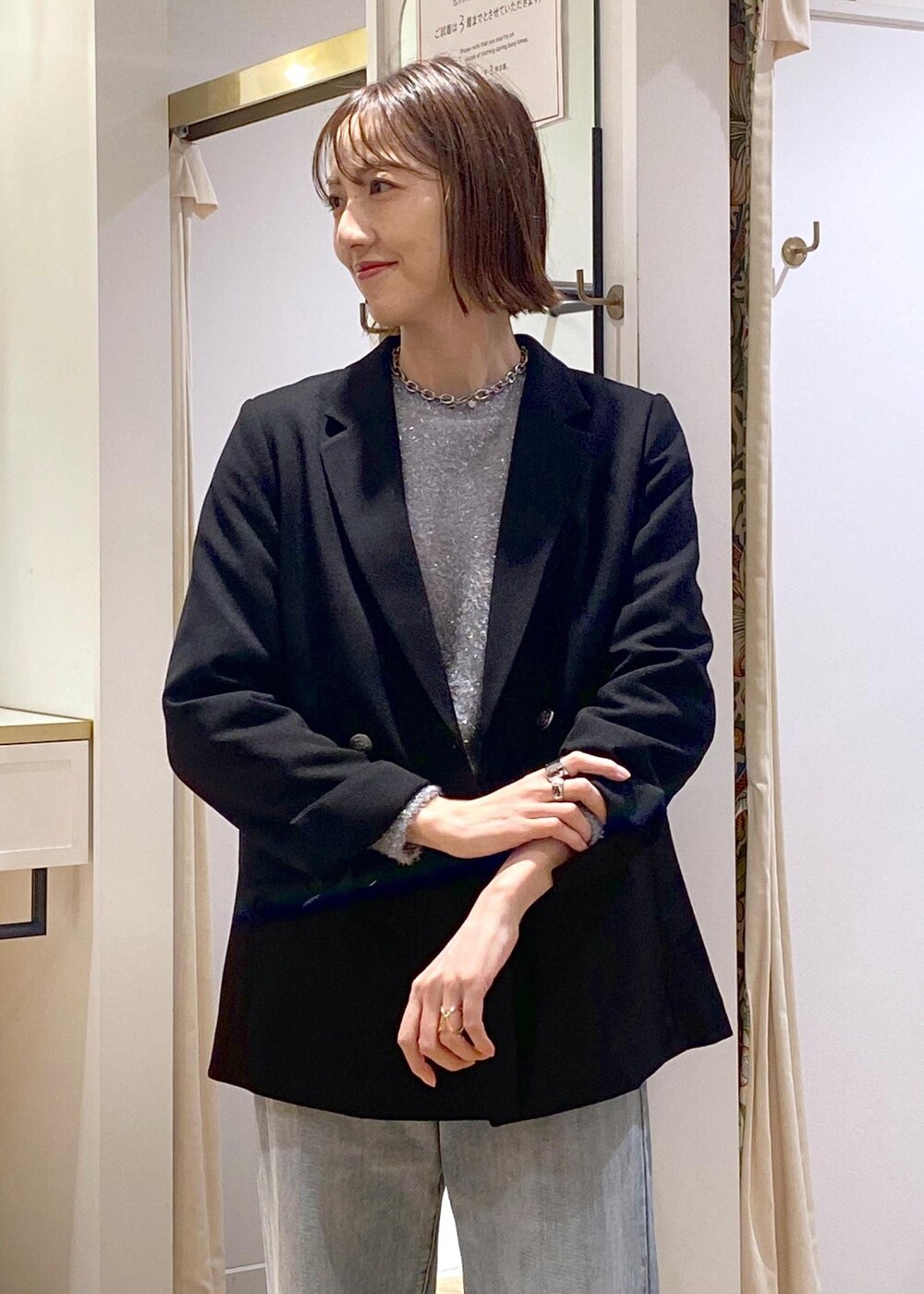 ブラック系のパンプス、グレー系のニット/セーター、ブルー系のデニムパンツを着用したレディースの冬コーディネートの6枚目の写真