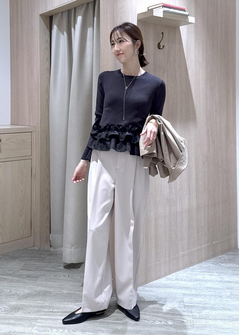 ベージュ系のその他パンツ、ブラック系のショルダーバッグ、ブラック系のパンプスを着用したレディースの冬コーディネートの2枚目の写真