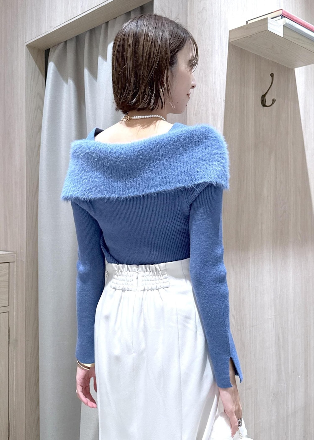 シルバー系のパンプス、ホワイト系のハンドバッグ、ブルー系のニット/セーターを着用したレディースの秋コーディネートの10枚目の写真