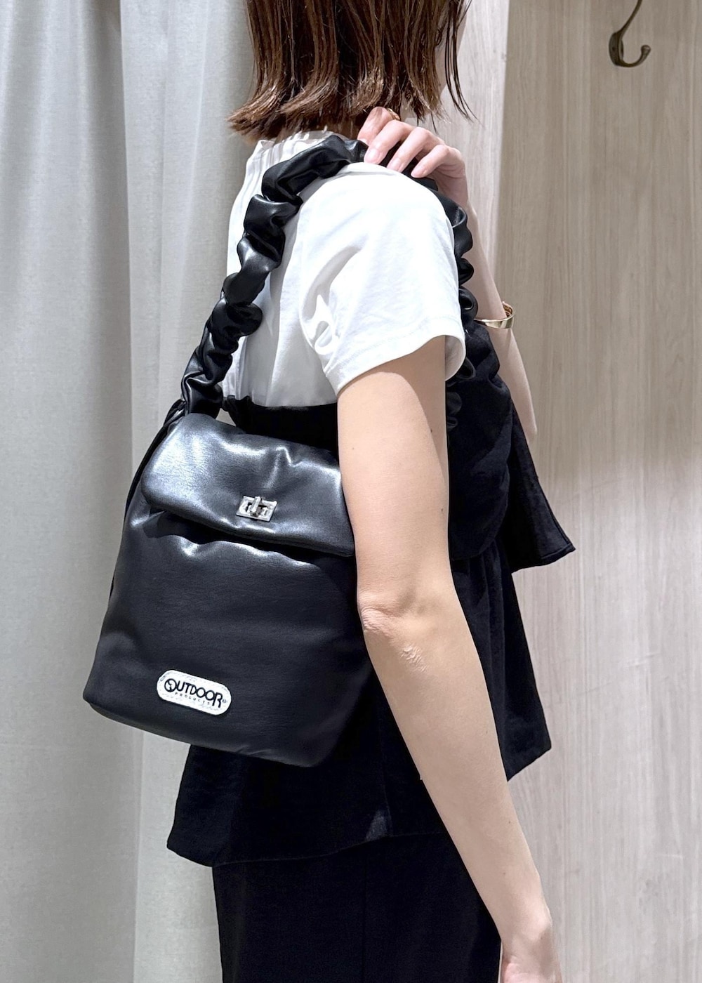 ブラック系のショルダーバッグ、ブラック系のパンプス、レッド系のカーディガン/ボレロを着用したレディースの春コーディネートの8枚目の写真