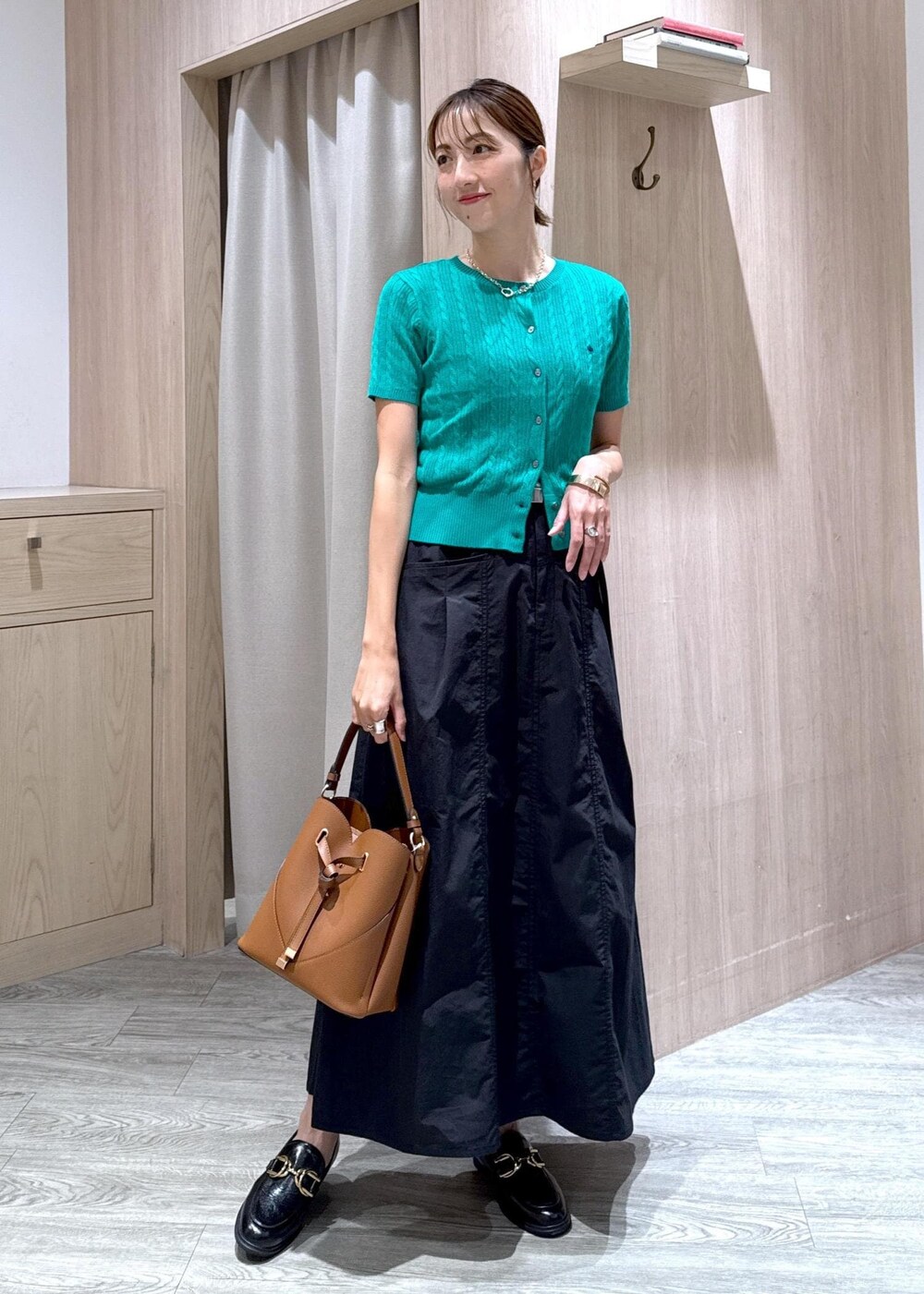 ブラック系のローファー、グリーン系のカーディガン/ボレロ、ブラウン系のショルダーバッグを着用したレディースの夏コーディネートの10枚目の写真