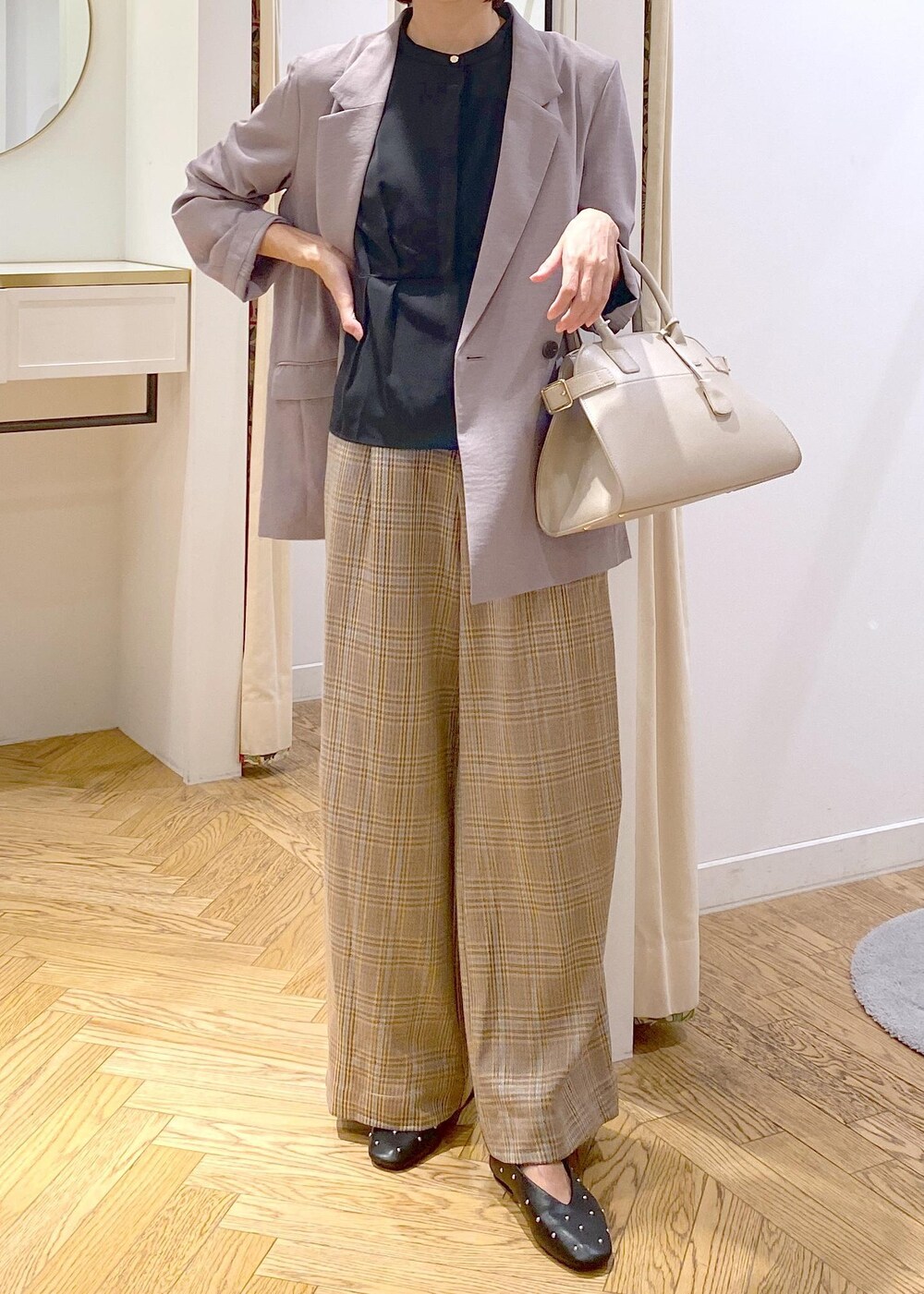グレー系のテーラードジャケット、ブラック系のバレエシューズ、ベージュ系のトートバッグを着用したレディースの秋コーディネートの5枚目の写真