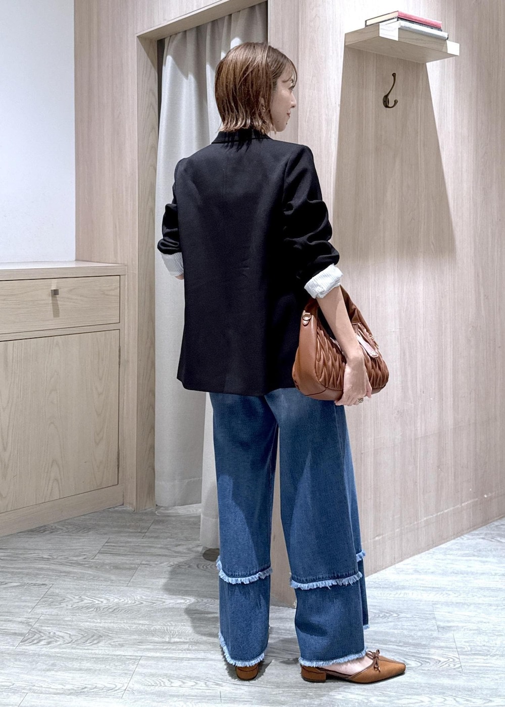 ブルー系のデニムパンツ、ブラック系のシャツ/ブラウス、イエロー系のパンプスを着用したレディースの秋コーディネートの4枚目の写真