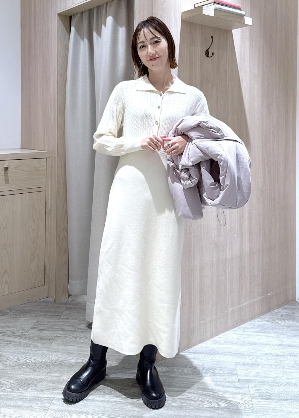 ブラック系のハンドバッグ、ピンク系のダウンジャケット/コート、ホワイト系のワンピースを着用したレディースの冬コーディネートの9枚目の写真