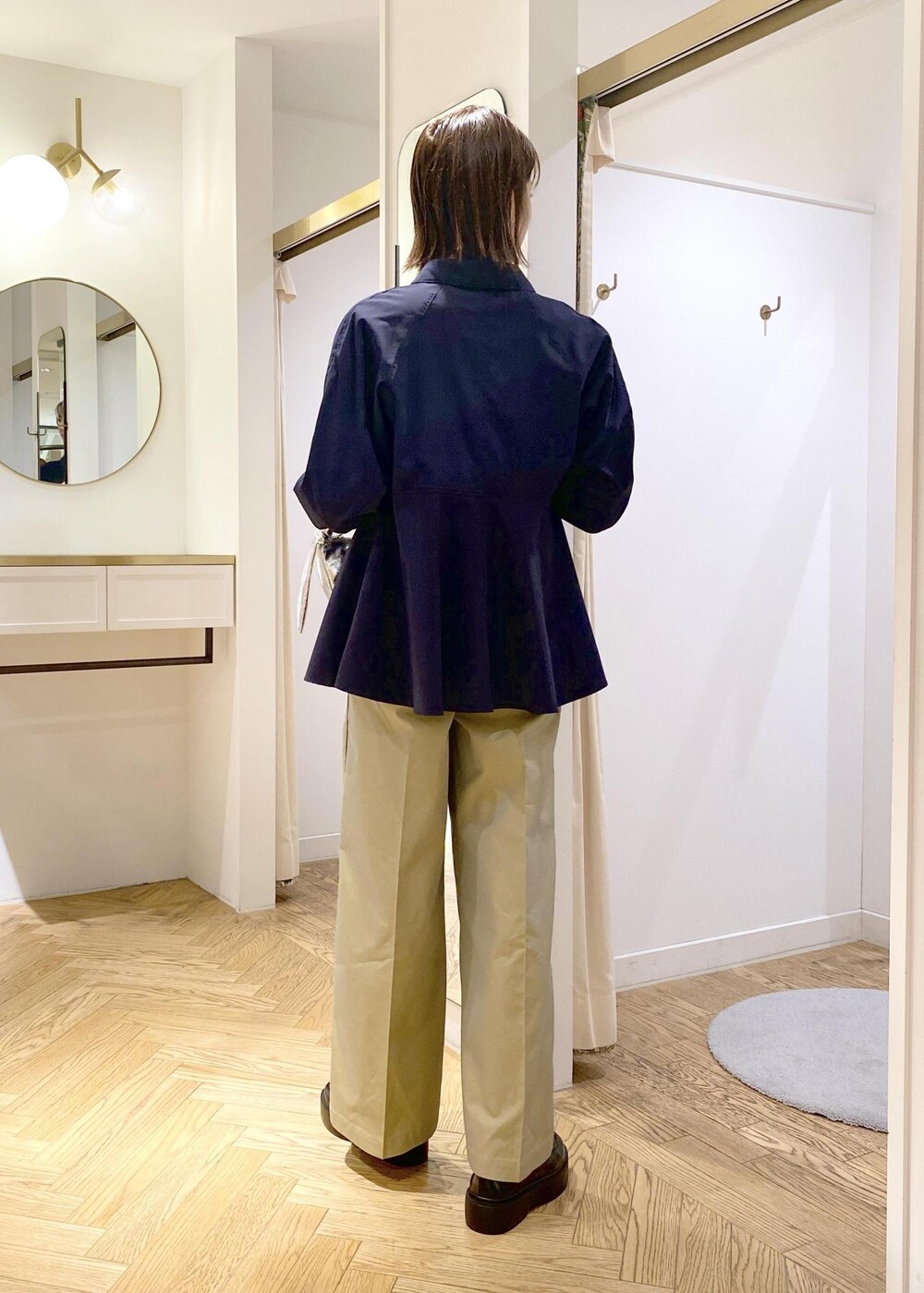 ブラック系のローファー、ベージュ系のスラックス、シルバー系のTシャツ/カットソーを着用したレディースの春コーディネートの2枚目の写真