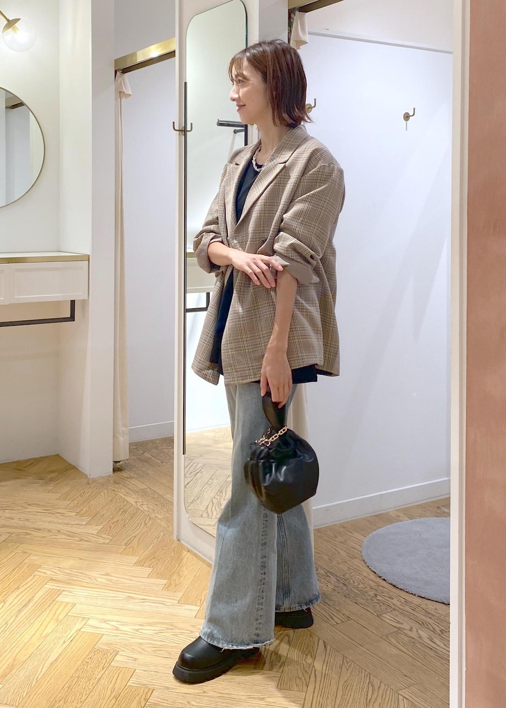 ブラック系のブーツ、ブラック系のTシャツ/カットソー、ブルー系のデニムパンツを着用したレディースの秋コーディネートの2枚目の写真