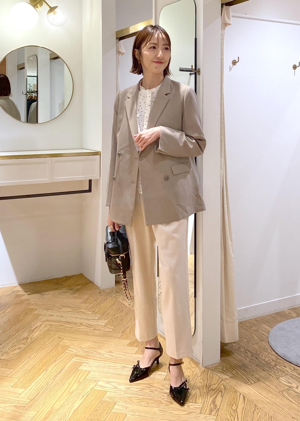 ブラック系のパンプス、ホワイト系のシャツ/ブラウス、ベージュ系のその他パンツを着用したレディースの冬コーディネートの3枚目の写真