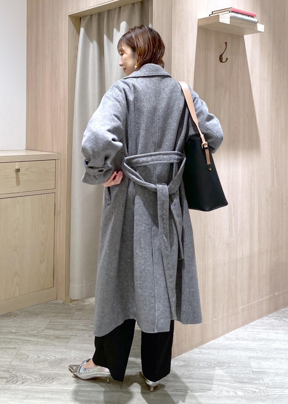 シルバー系のパンプス、ブラック系のスラックス、ブラック系のニット/セーターを着用したレディースの冬コーディネートの4枚目の写真