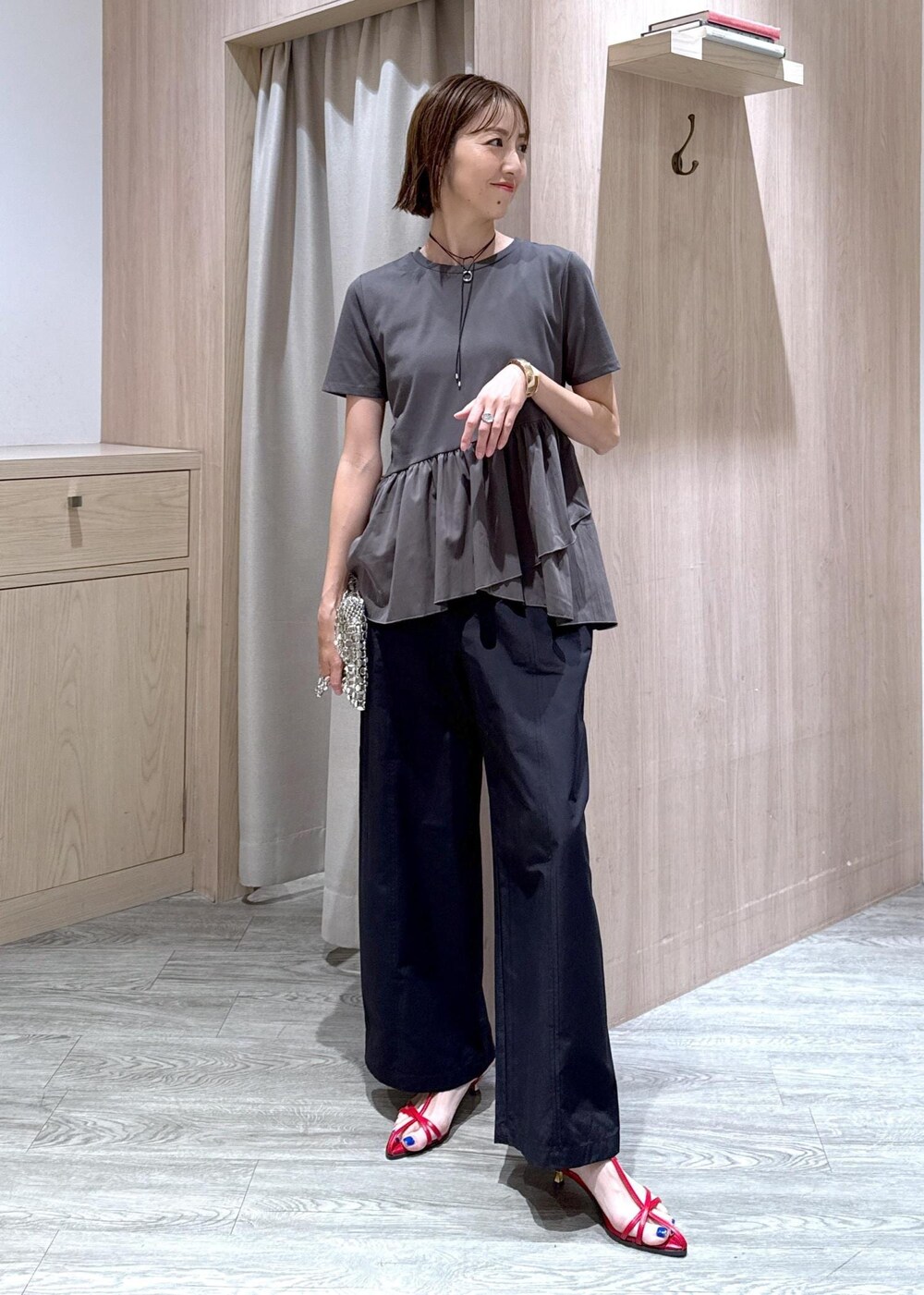 レッド系のサンダル、グレー系のTシャツ/カットソー、ブラック系のその他パンツを着用したレディースの夏コーディネートの2枚目の写真