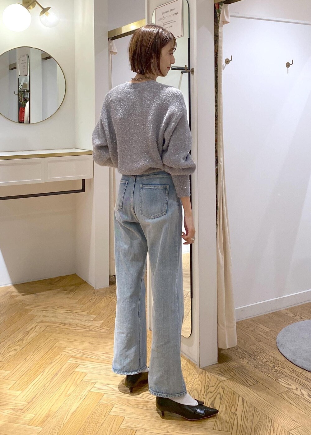 ブラック系のパンプス、グレー系のニット/セーター、ブルー系のデニムパンツを着用したレディースの冬コーディネートの9枚目の写真