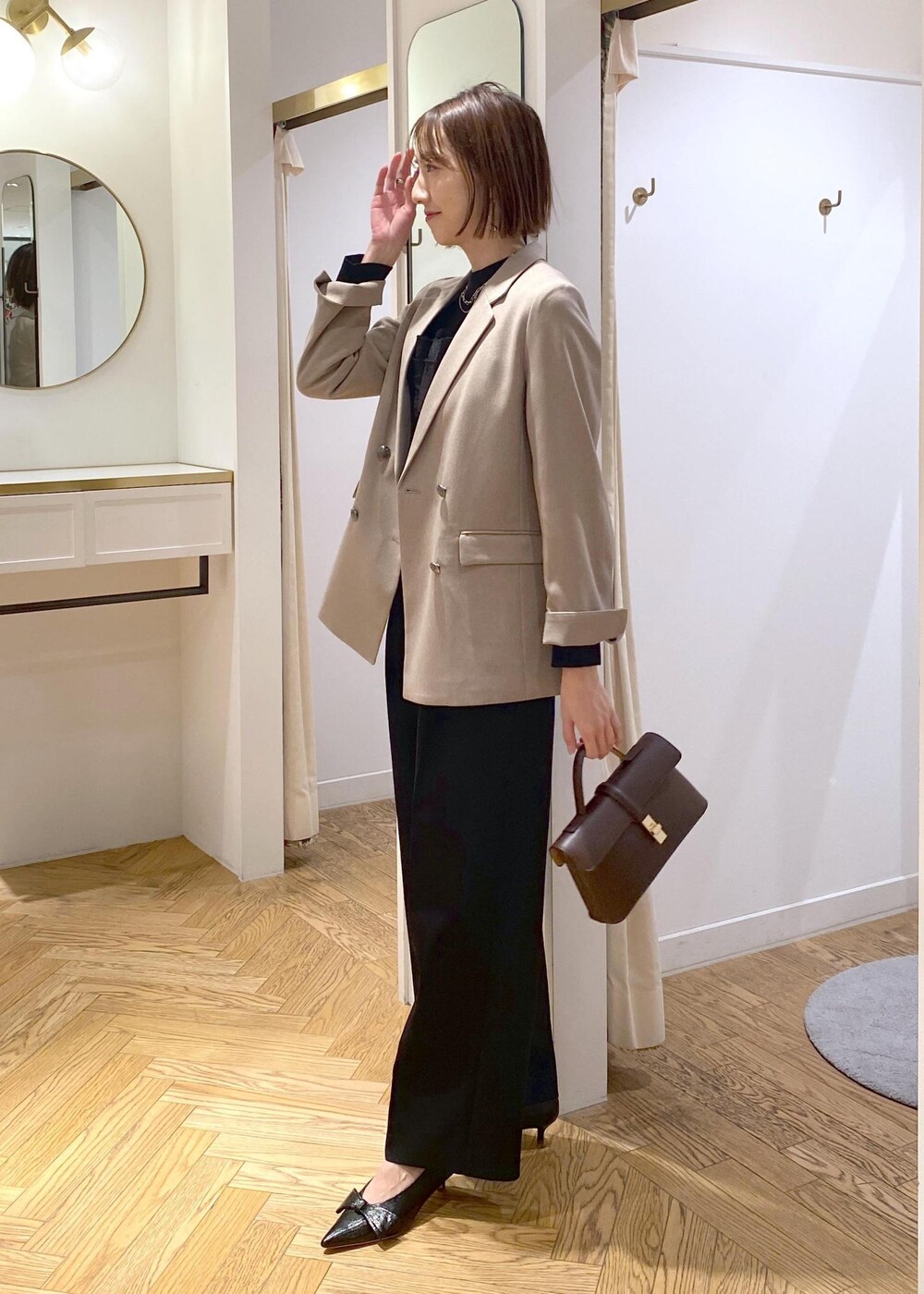 ブラック系のパンプス、ブラック系のニット/セーター、ブラック系のスラックスを着用したレディースの冬コーディネートの4枚目の写真