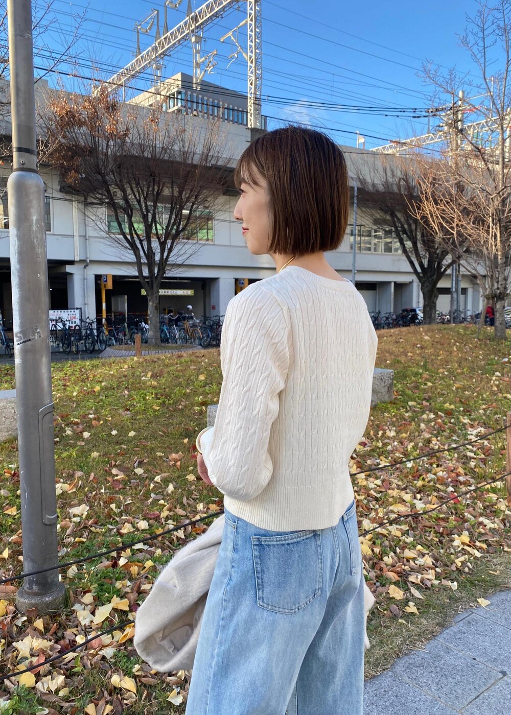 ブラック系のパンプス、ホワイト系のカーディガン/ボレロ、ベージュ系のその他アウターを着用したレディースの冬コーディネートの8枚目の写真