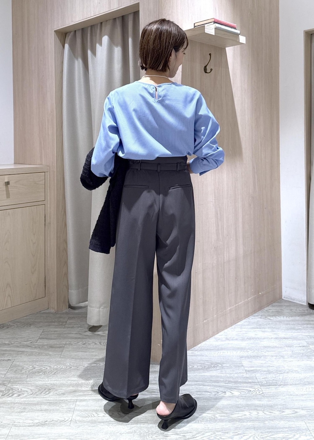 ブラック系のハンドバッグ、ブルー系のカーディガン/ボレロ、グレー系のその他パンツを着用したレディースの秋コーディネートの10枚目の写真