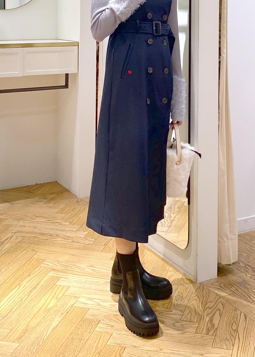ブラック系のブーツ、ホワイト系のショルダーバッグ、ブルー系のニット/セーターを着用したレディースの秋コーディネートの6枚目の写真