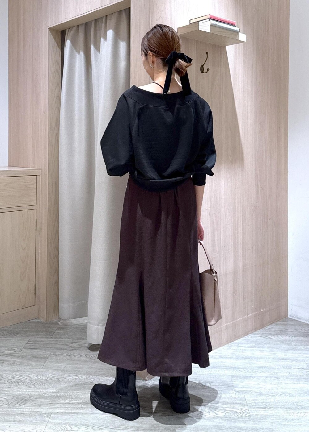 ブラック系のキャミソール、ブラウン系のスカート、ブラック系のブーツを着用したレディースの秋コーディネートの4枚目の写真