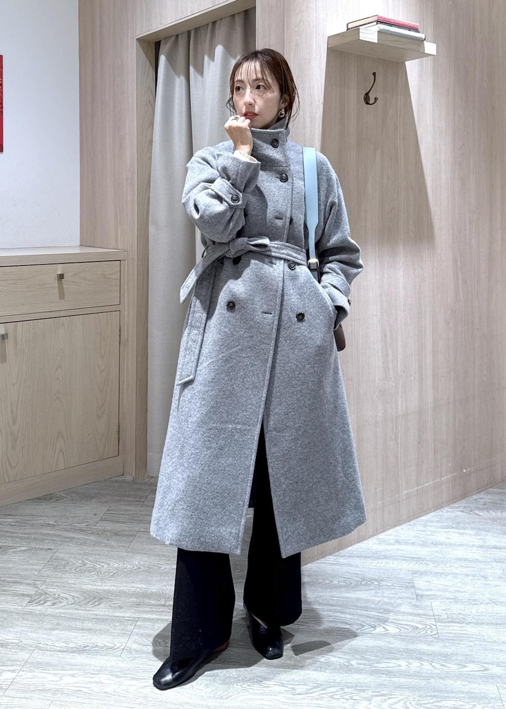 ホワイト系のニット/セーター、グレー系のその他アウター、ブラック系のスラックスを着用したレディースの冬コーディネートの3枚目の写真