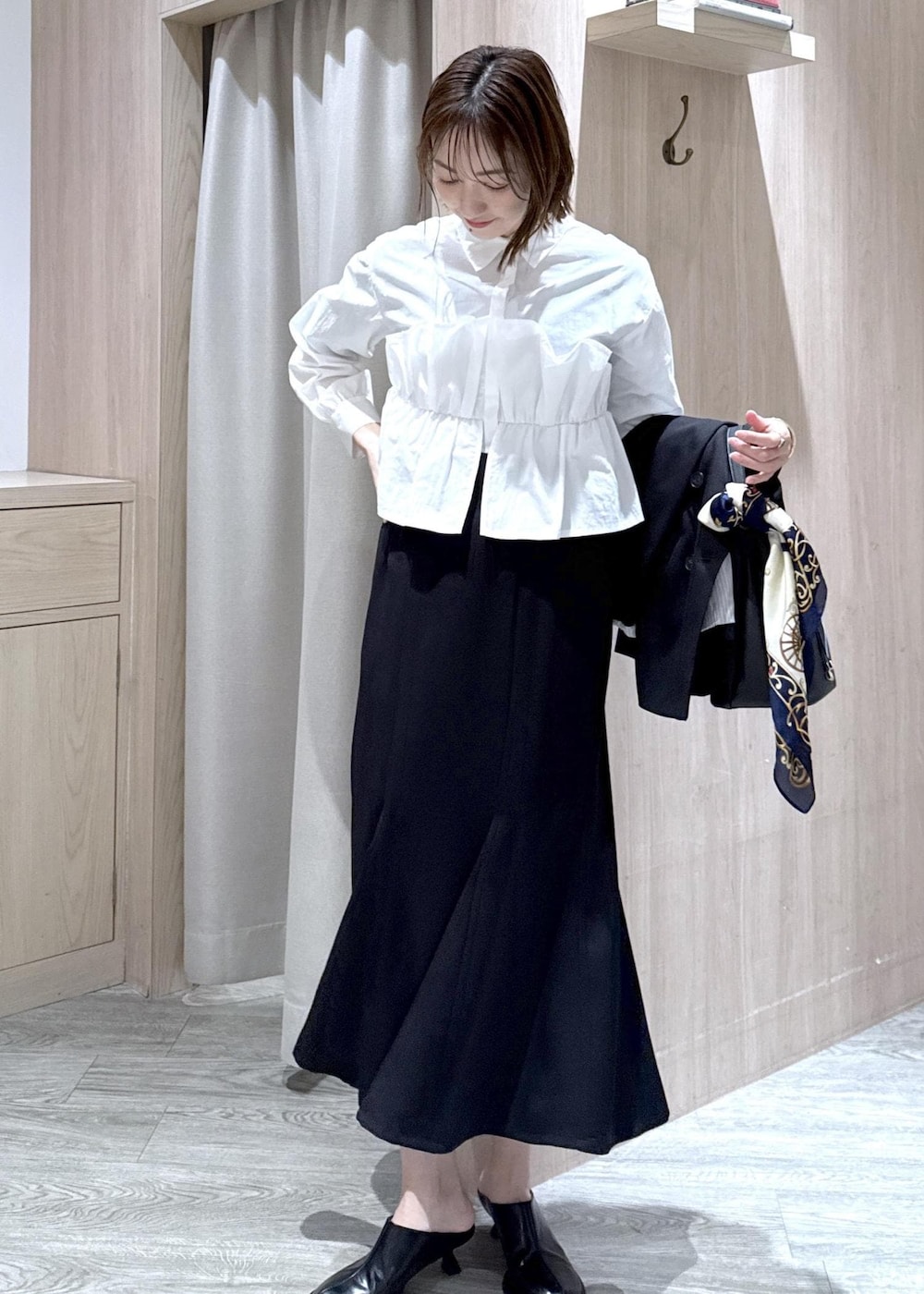 ブラック系のショルダーバッグ、ブラック系のスカート、ブラック系のテーラードジャケットを着用したレディースの冬コーディネートの8枚目の写真