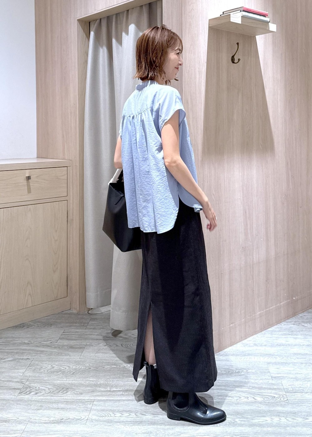 グレー系のタンクトップ、ホワイト系のテーラードジャケット、ブラック系のトートバッグを着用したレディースの夏コーディネートの3枚目の写真