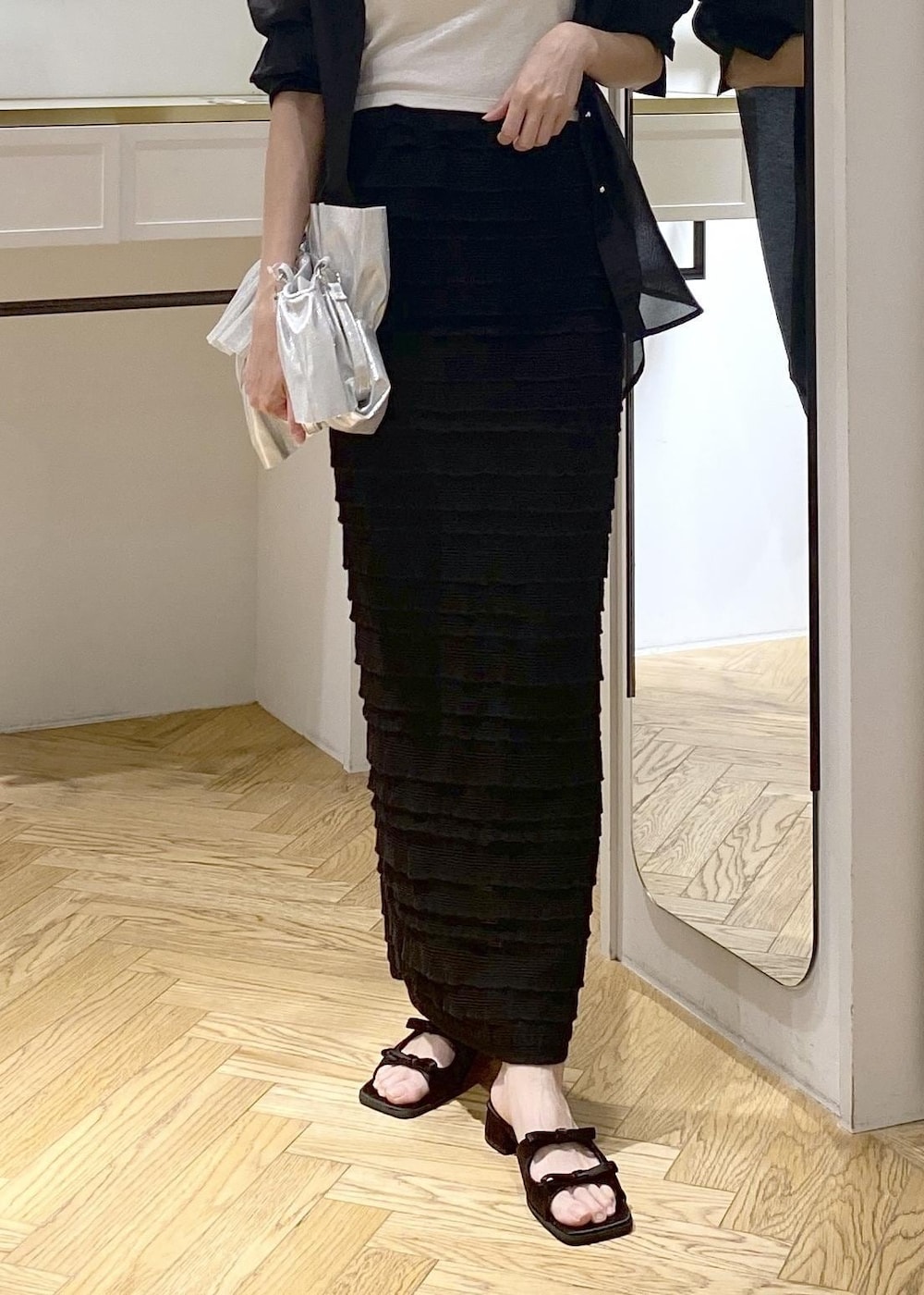 ブラック系のサンダル、ブラック系のスカート、シルバー系のキャミソールを着用したレディースの夏コーディネートの5枚目の写真