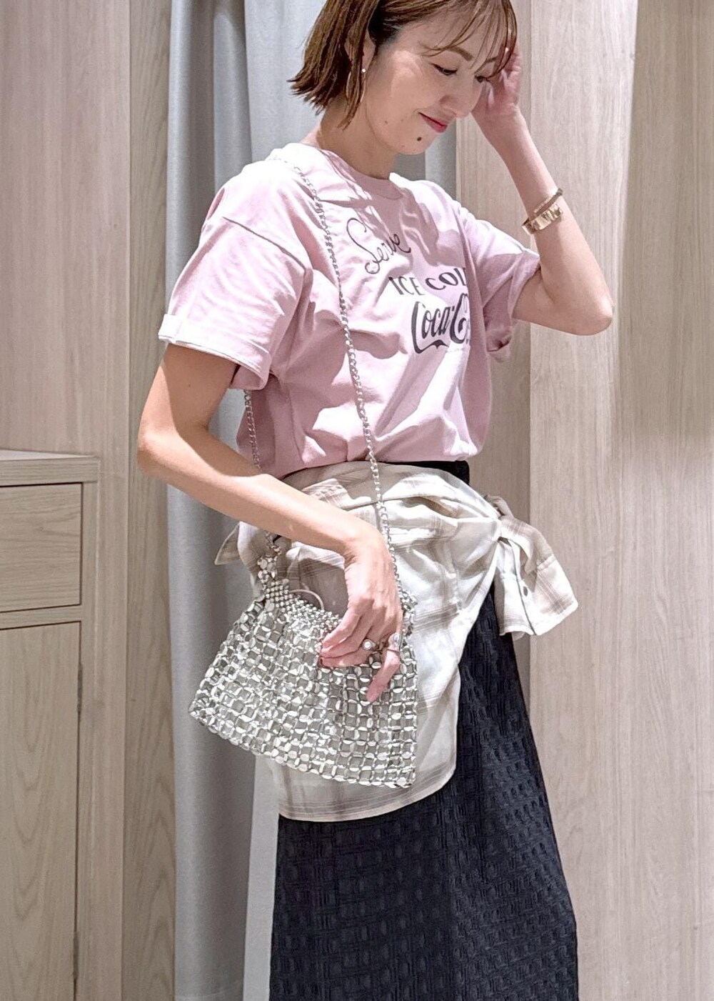 シルバー系のハンドバッグ、ベージュ系のシャツ/ブラウス、グレー系のスカートを着用したレディースの夏コーディネートの6枚目の写真