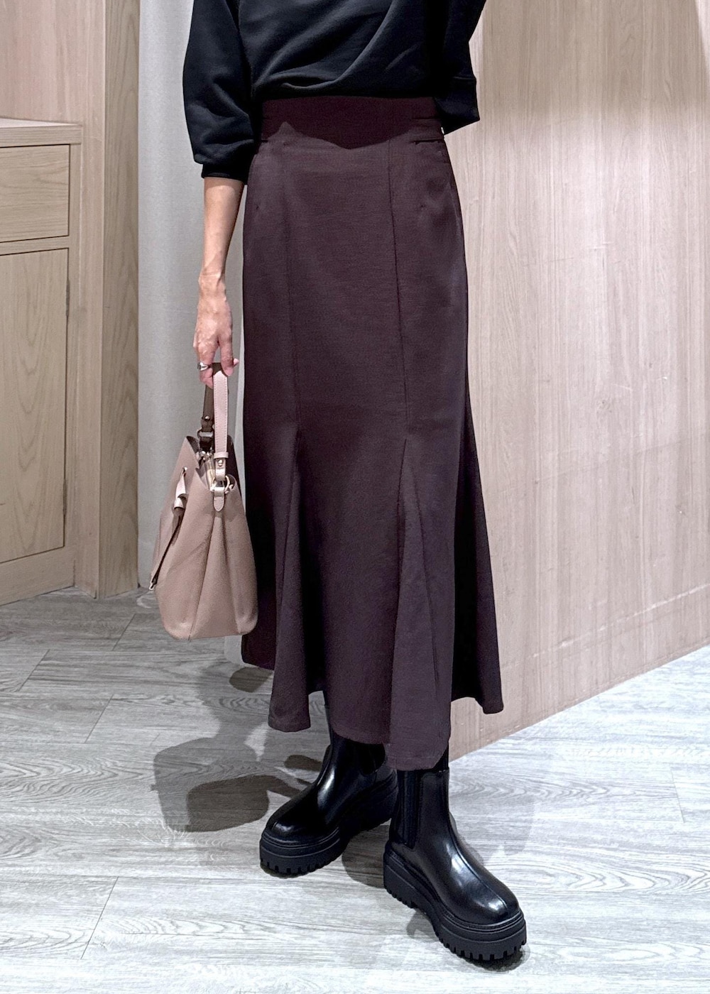 ブラック系のキャミソール、ブラウン系のスカート、ブラック系のブーツを着用したレディースの秋コーディネートの6枚目の写真