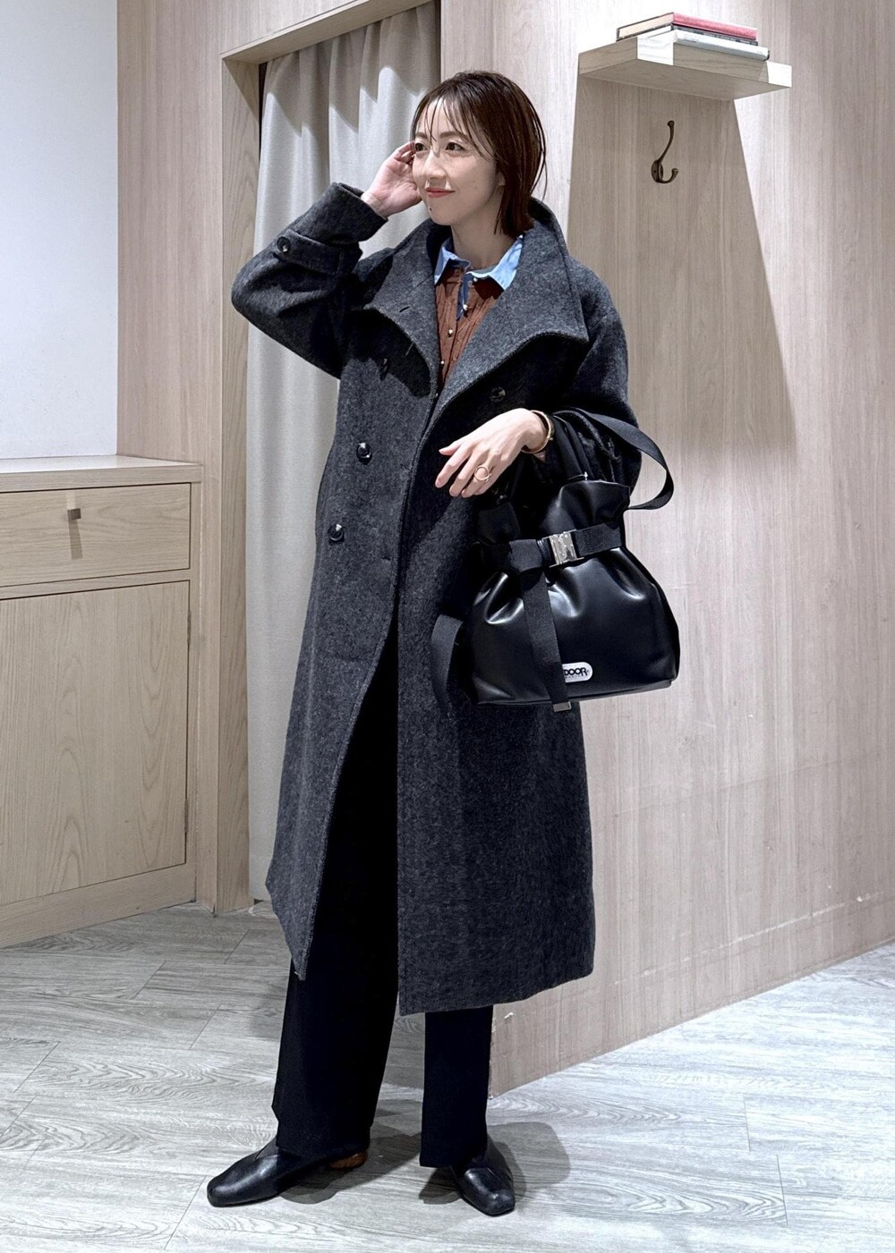 ブラック系のスラックス、グレー系のその他アウター、ブルー系のシャツ/ブラウスを着用したレディースの冬コーディネートの2枚目の写真