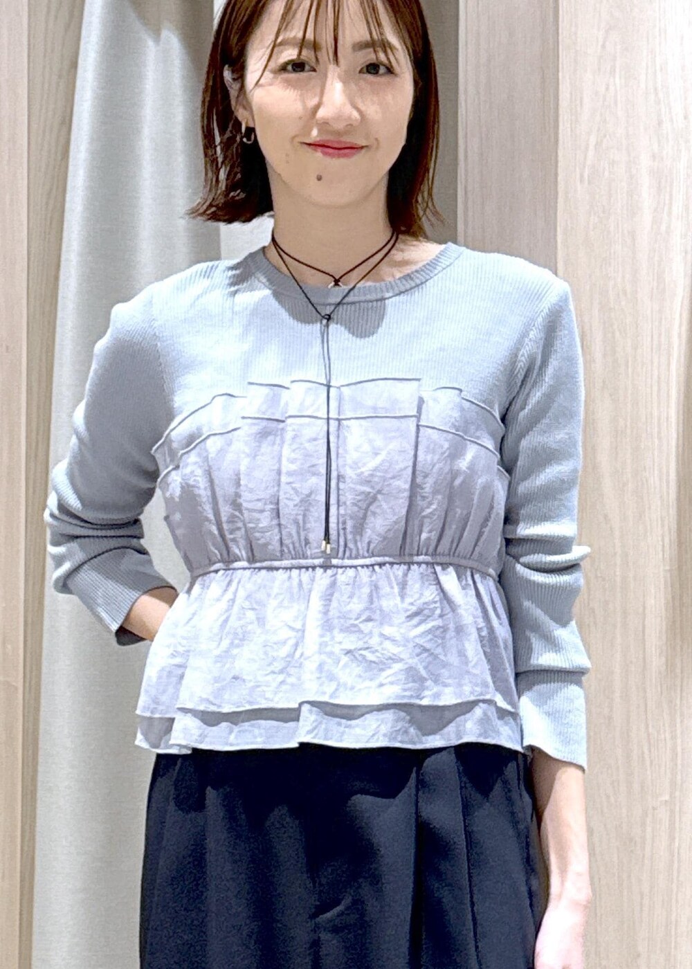 ブラック系のショルダーバッグ、ブラック系のパンプス、ブルー系のニット/セーターを着用したレディースの春コーディネートの8枚目の写真