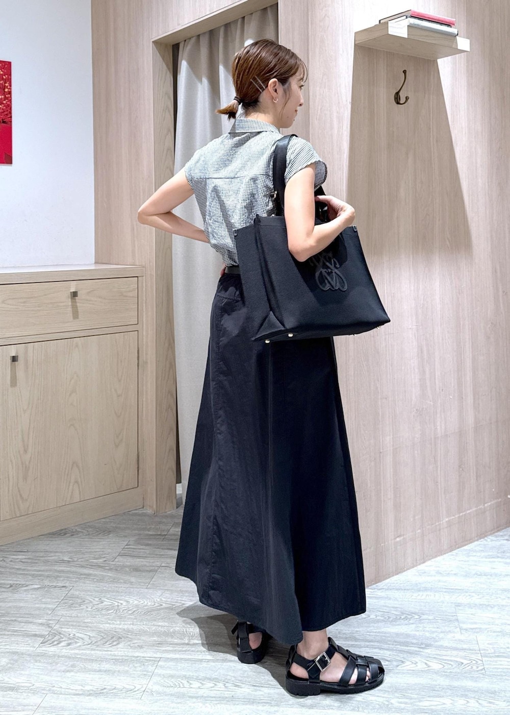 ブラック系のシャツ/ブラウス、ブラック系のトートバッグ、ブラック系のスカートを着用したレディースの夏コーディネートの3枚目の写真