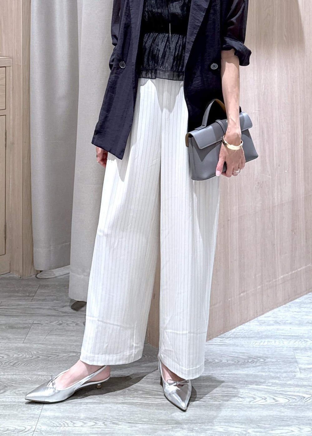 グレー系のショルダーバッグ、シルバー系のパンプス、ブラック系のTシャツ/カットソーを着用したレディースの夏コーディネートの5枚目の写真