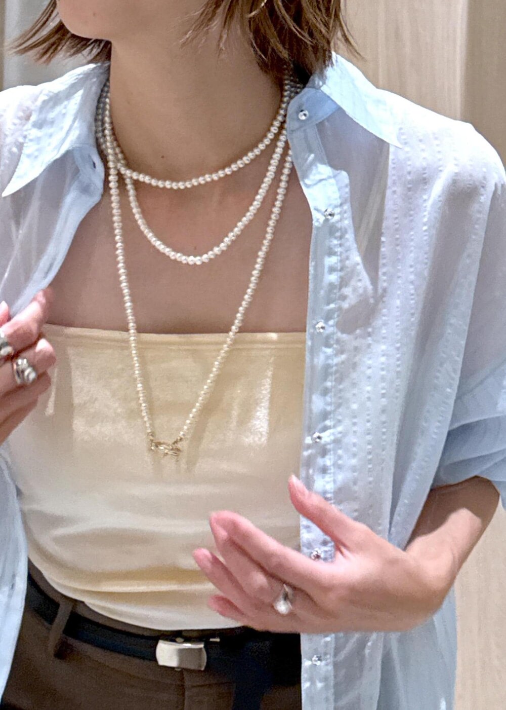 グリーン系のスラックス、ブラック系のパンプス、ベージュ系のボストンバッグを着用したレディースの秋コーディネートの8枚目の写真