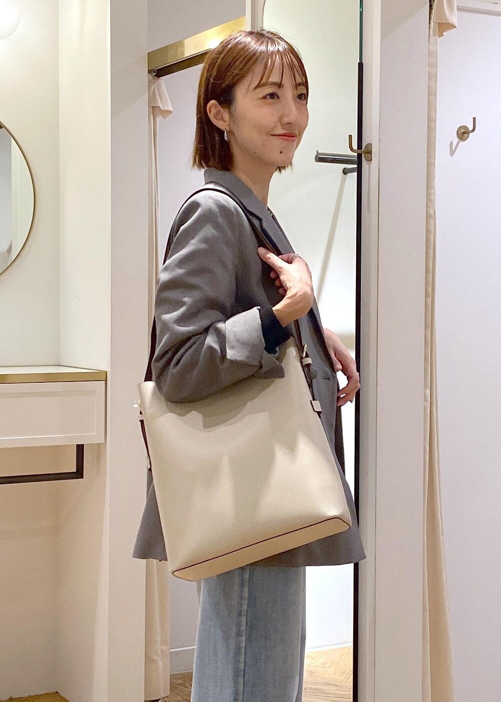 ベージュ系のショルダーバッグ、ブラック系のバレエシューズ、グレー系のテーラードジャケットを着用したレディースの秋コーディネートの5枚目の写真