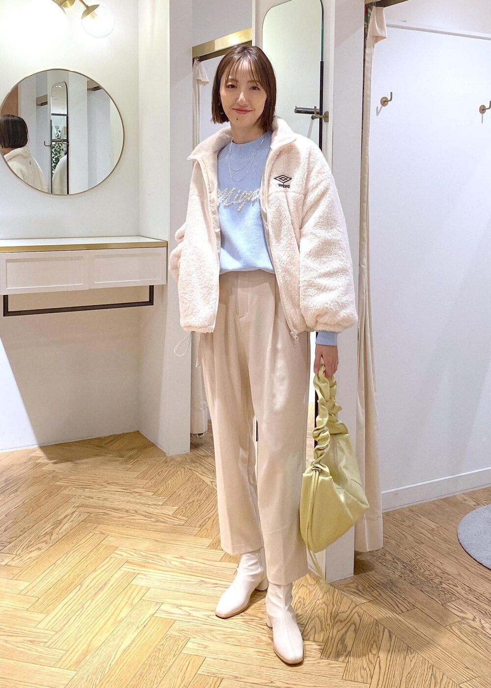 ホワイト系のブーツ、ホワイト系のブルゾン、ブルー系のニット/セーターを着用したレディースの冬コーディネートの3枚目の写真