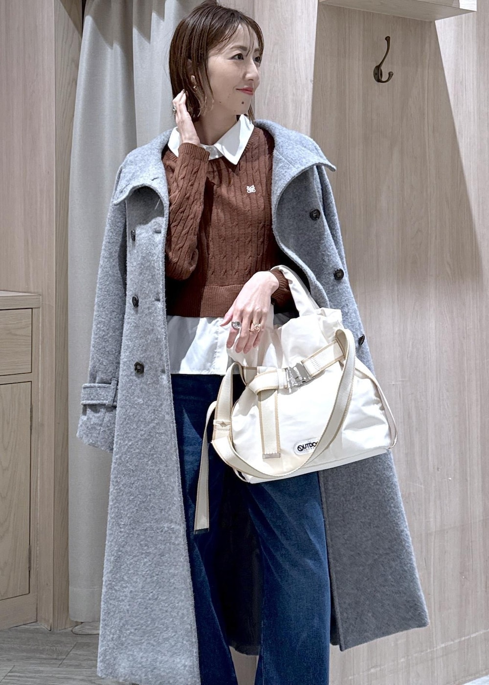 グレー系のその他アウター、ブラウン系のニット/セーター、ブルー系のデニムパンツを着用したレディースの冬コーディネートの4枚目の写真