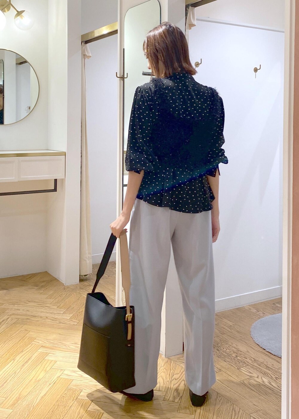 ブラック系のショルダーバッグ、ブラック系のバレエシューズ、ブラック系のキャミソールを着用したレディースの秋コーディネートの2枚目の写真