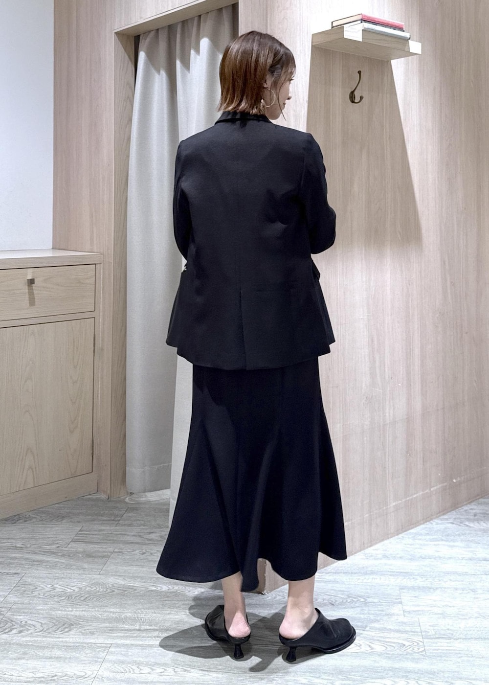 ブラック系のショルダーバッグ、ブラック系のスカート、ブラック系のテーラードジャケットを着用したレディースの冬コーディネートの2枚目の写真