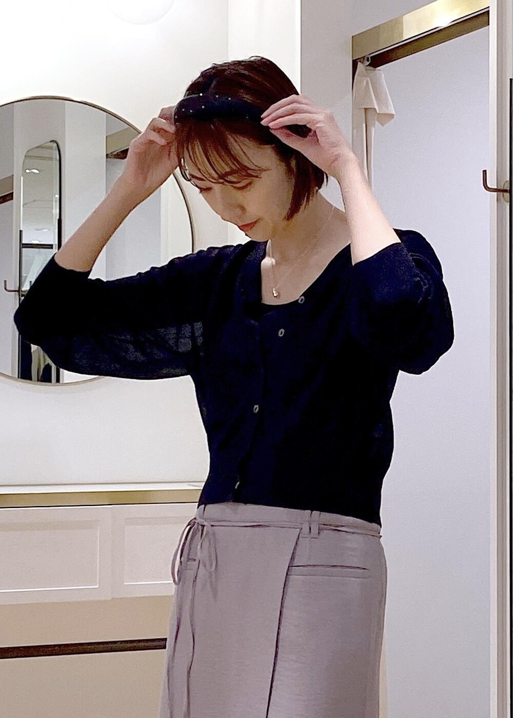 ブラック系のキャミソール、ブラック系のハンドバッグ、ホワイト系のサンダルを着用したレディースの夏コーディネートの5枚目の写真