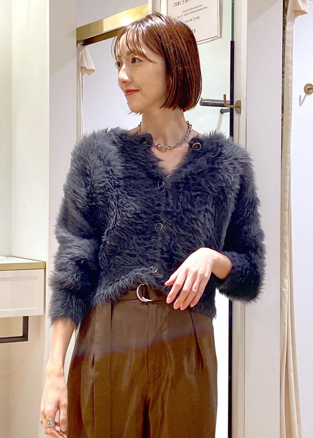 ブラック系のパンプス、グレー系のカーディガン/ボレロ、ブラウン系のピーコートを着用したレディースの冬コーディネートの9枚目の写真