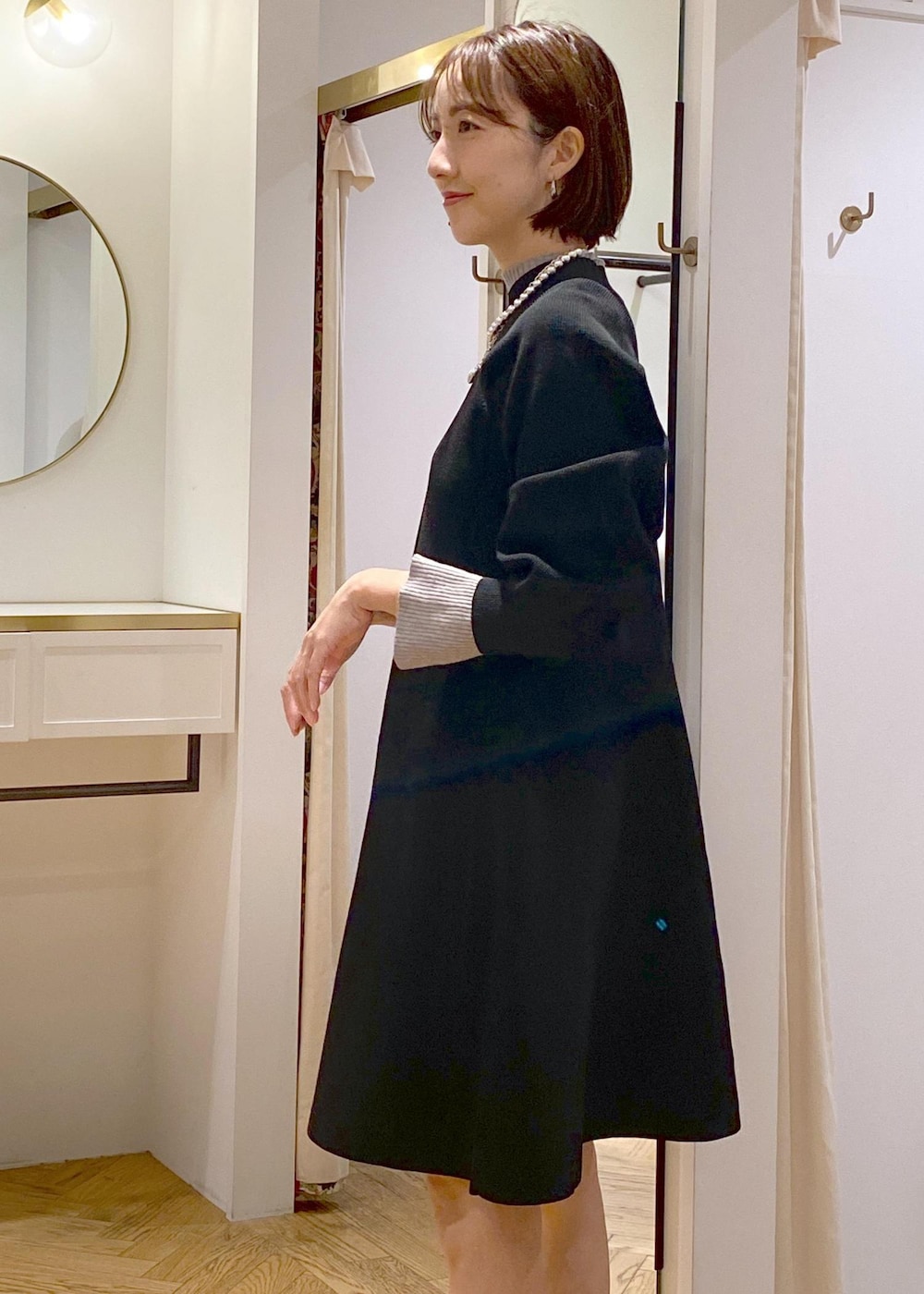 ブラック系のブーツ、ブラック系のワンピース、グレー系のニット/セーターを着用したレディースの秋コーディネートの8枚目の写真