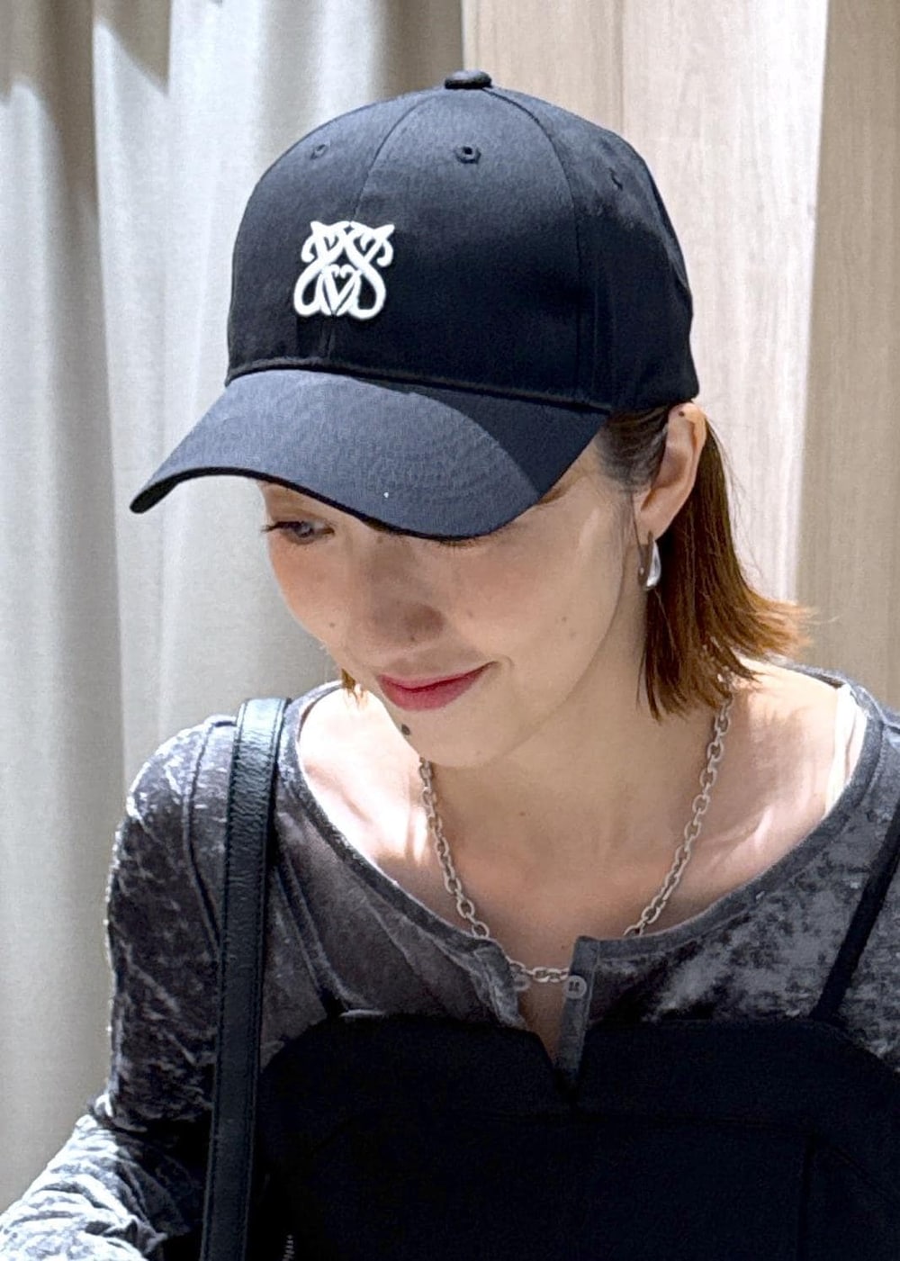 ブラック系のキャミソール、ブラック系のショルダーバッグ、グレー系のカーディガン/ボレロを着用したレディースの秋コーディネートの8枚目の写真