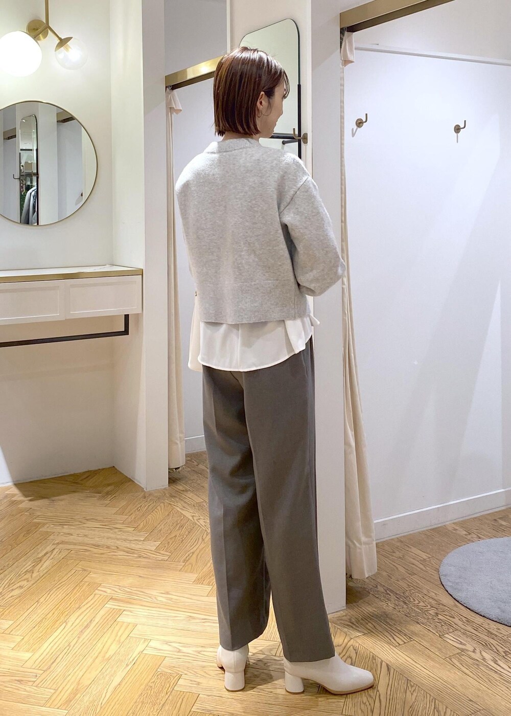 ホワイト系のブーツ、ホワイト系のシャツ/ブラウス、グレー系のカーディガン/ボレロを着用したレディースの冬コーディネートの3枚目の写真