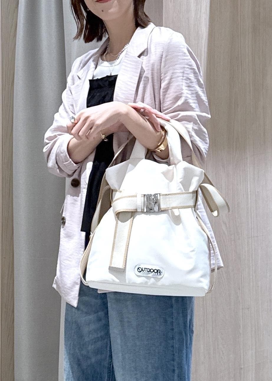 ホワイト系のトートバッグ、ブルー系のデニムパンツ、ブラック系のニット/セーターを着用したレディースの春コーディネートの4枚目の写真