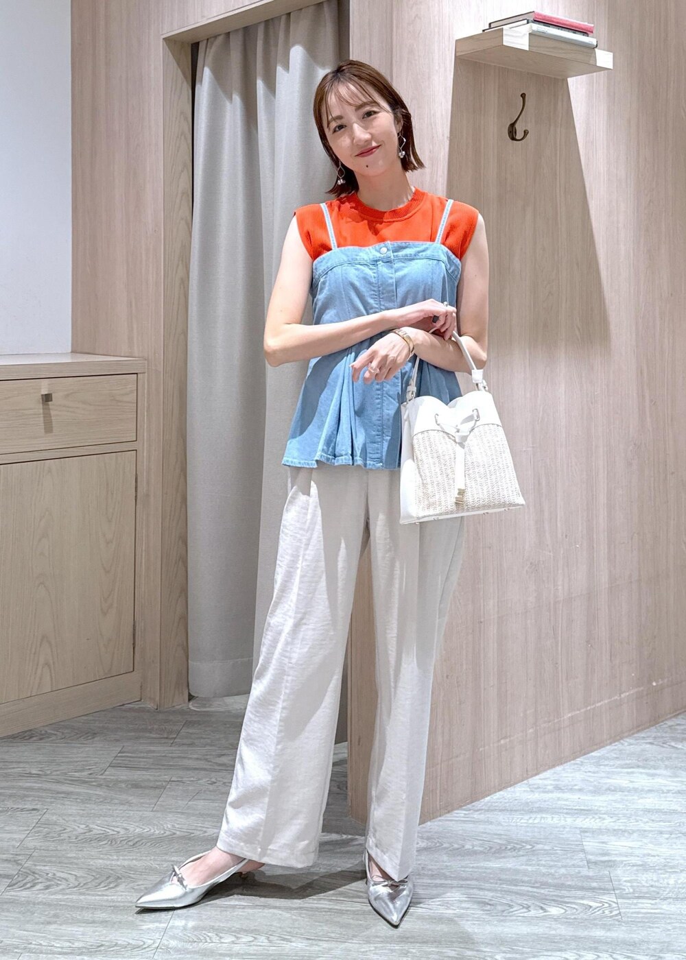 シルバー系のパンプス、ブルー系のキャミソール、オレンジ系のニット/セーターを着用したレディースの夏コーディネートの3枚目の写真