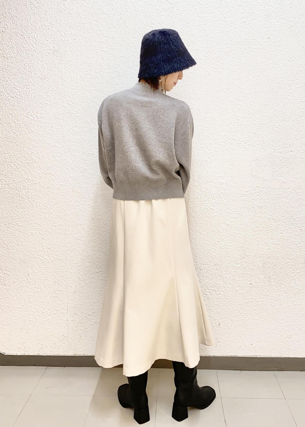 グレー系のハンドバッグ、ブラック系のブーツ、グレー系のニット/セーターを着用したレディースの冬コーディネートの3枚目の写真