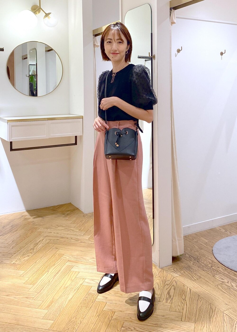 ブラック系のローファー、ブラック系のニット/セーター、ピンク系のスラックスを着用したレディースの夏コーディネートの8枚目の写真