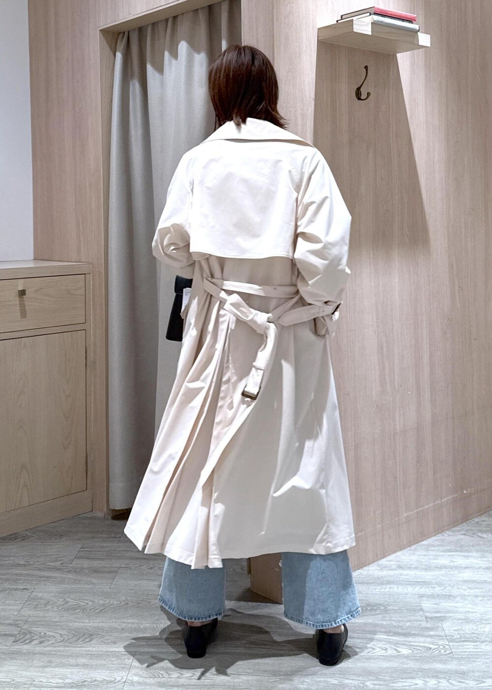 ブラック系のハンドバッグ、ブラック系のバレエシューズ、ホワイト系のトレンチコートを着用したレディースの春コーディネートの4枚目の写真