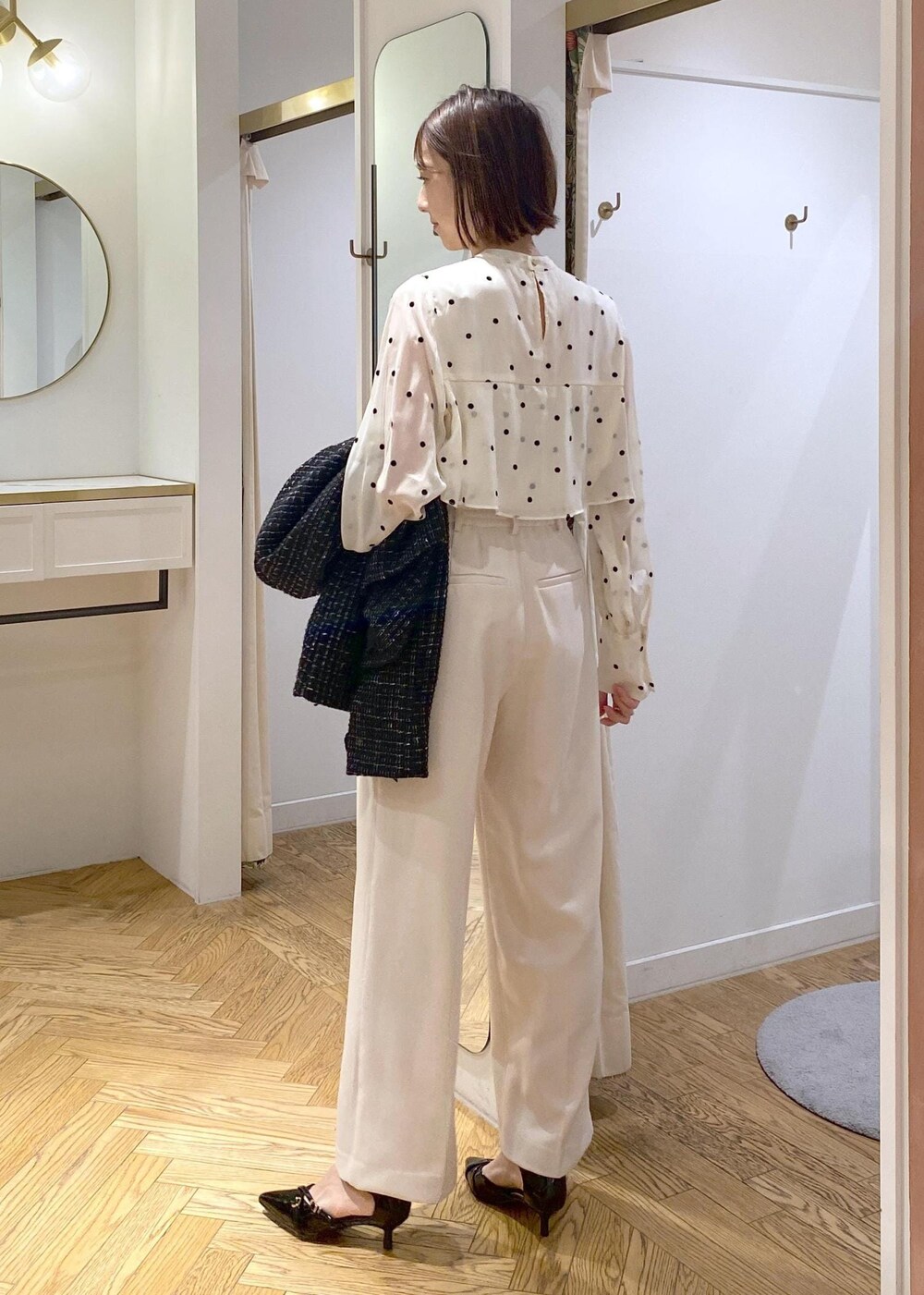 ブラック系のパンプス、ベージュ系のシャツ/ブラウス、ホワイト系のスラックスを着用したレディースの冬コーディネートの10枚目の写真