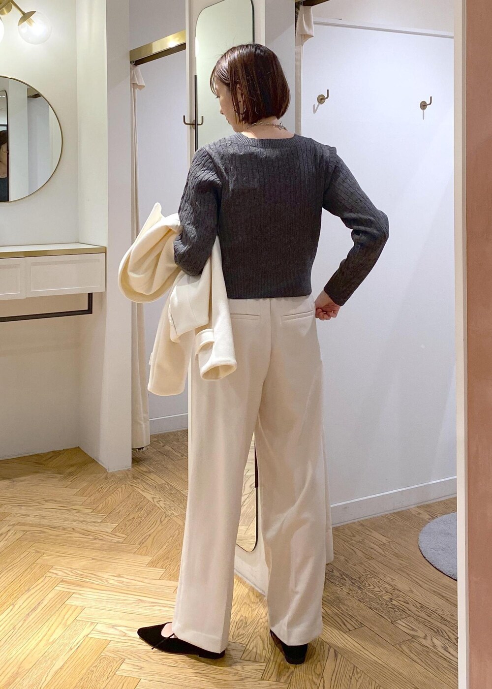 ブルー系のハンドバッグ、ホワイト系のブルゾン、ブラック系のパンプスを着用したレディースの冬コーディネートの7枚目の写真