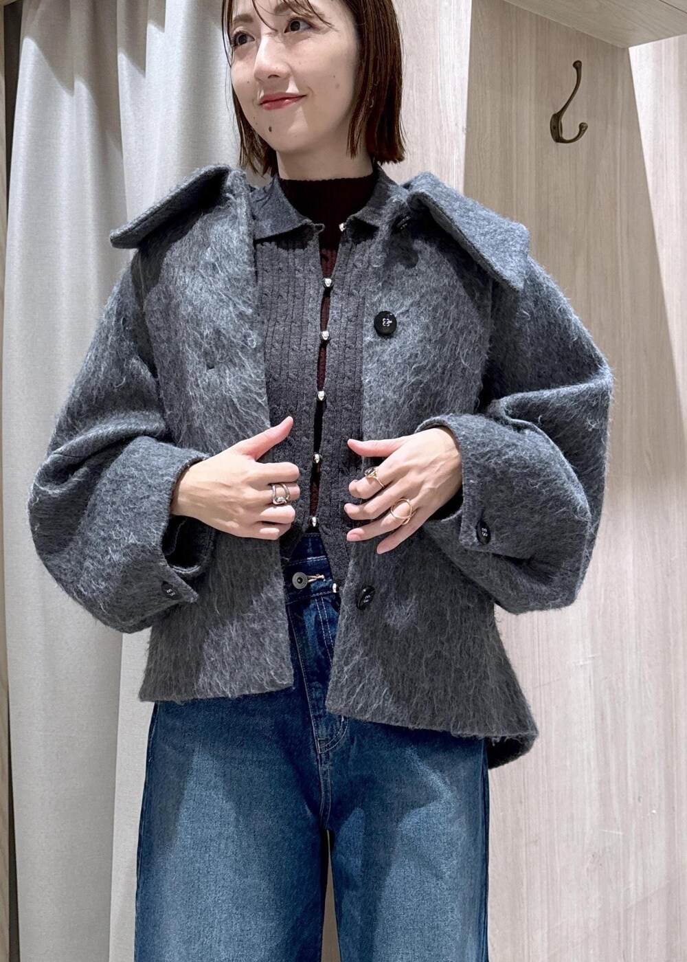 ブラック系のショルダーバッグ、ブルー系のデニムパンツ、グレー系のブルゾンを着用したレディースの冬コーディネートの4枚目の写真